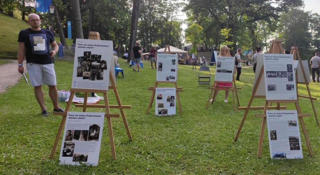 Diskusijas vadītājs Āris Adlers iepazīstas ar izstādi “Tavs un mans Čiekurkalns: dzimtu stāsti”. Foto: RCB